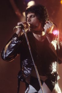 Freddie Mercury in his younger days, known for his spectacular stage presence and exhilarating vocal performances.