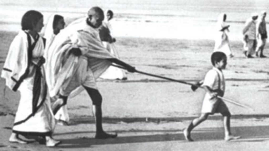 File Picture: Young Kanu Gandhi pulls Mahatma Gandhi's stick during the famous Dandi March (Salt Satyagraha)