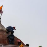 protestor hoist flag at red fort